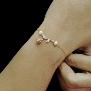 Rose gold finish bracelet with a rose, zircon-studded leaves, and two pearls